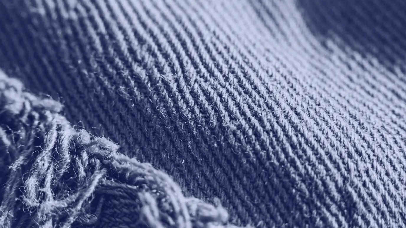 Haki pamuklu dimi kumaşın yakın çekimi: belirgin diyagonal çizgiler ve köşede saçaklanmış kalın iplikler