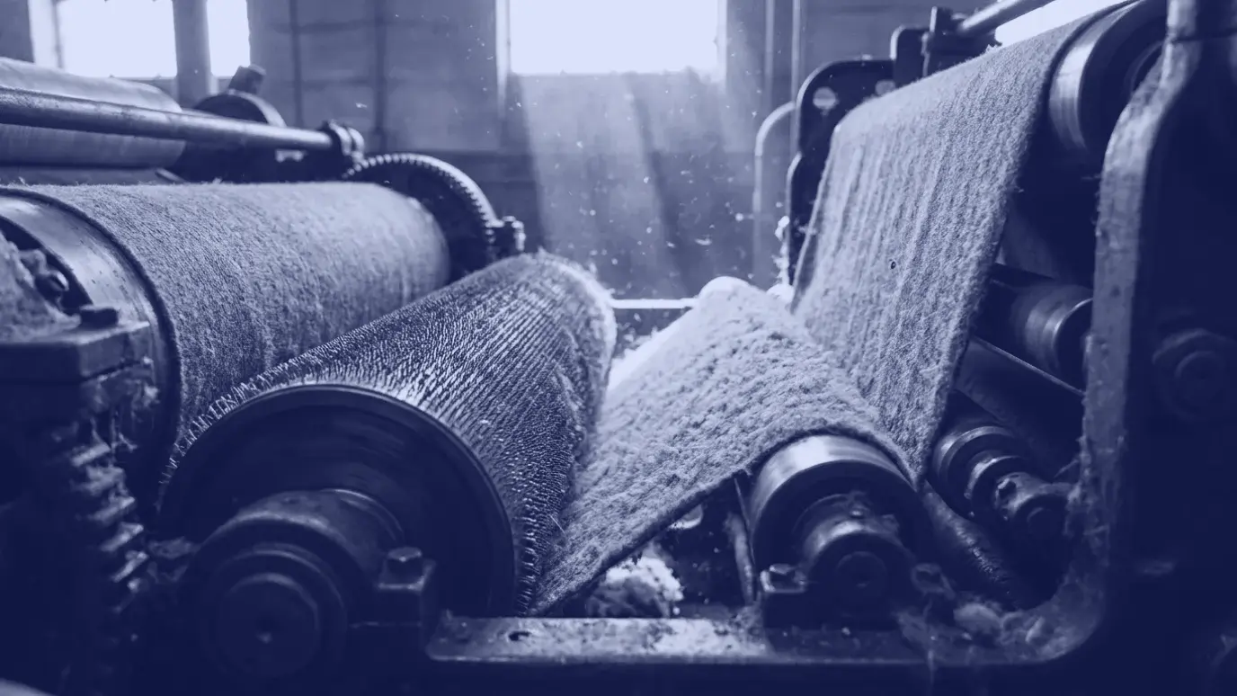 Knit fabric running over wire-covered rotating cylinders in a napping machine, leaving with a fluffy raised surface