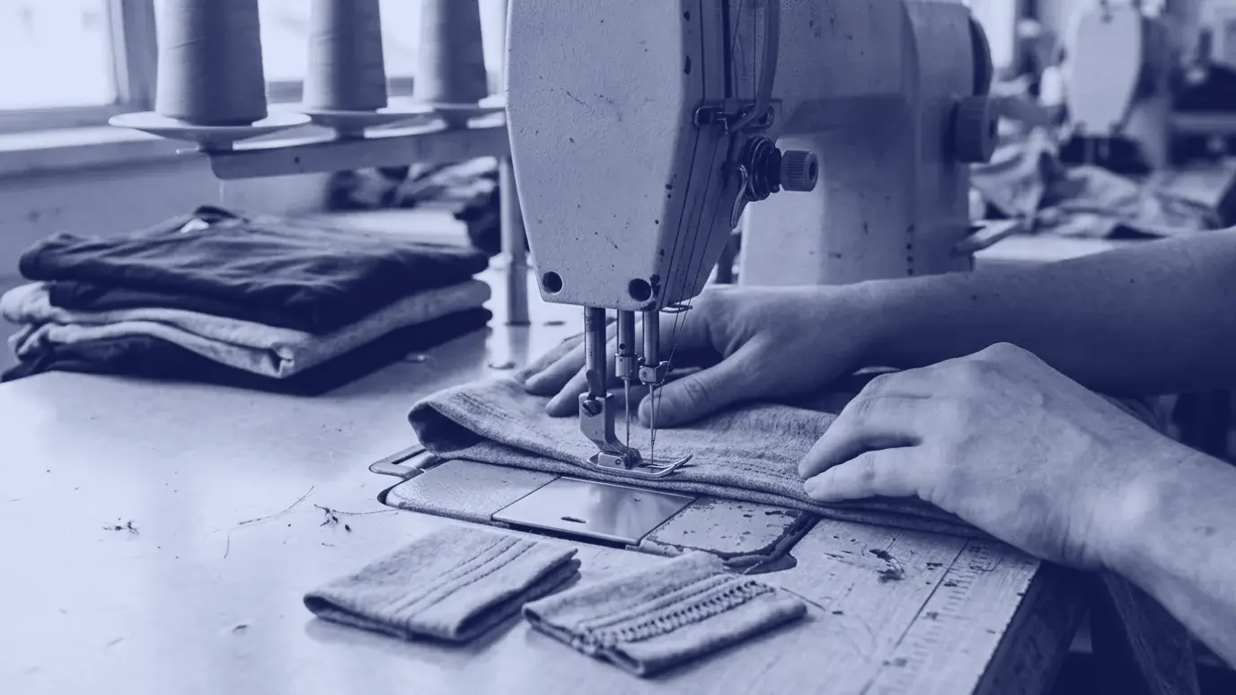 Reçme makinesinde gri örme kumaşın etek payına paralel sıralar dikerken eller; yanda dikilmiş etek örnekleri